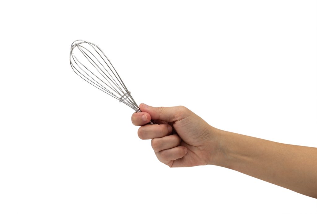 30684860 female hand with a kitchen whisk isolated on white background