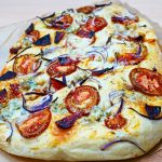 Focaccia au chorizo et gorgonzola, avec des tomates et des oignons rouges