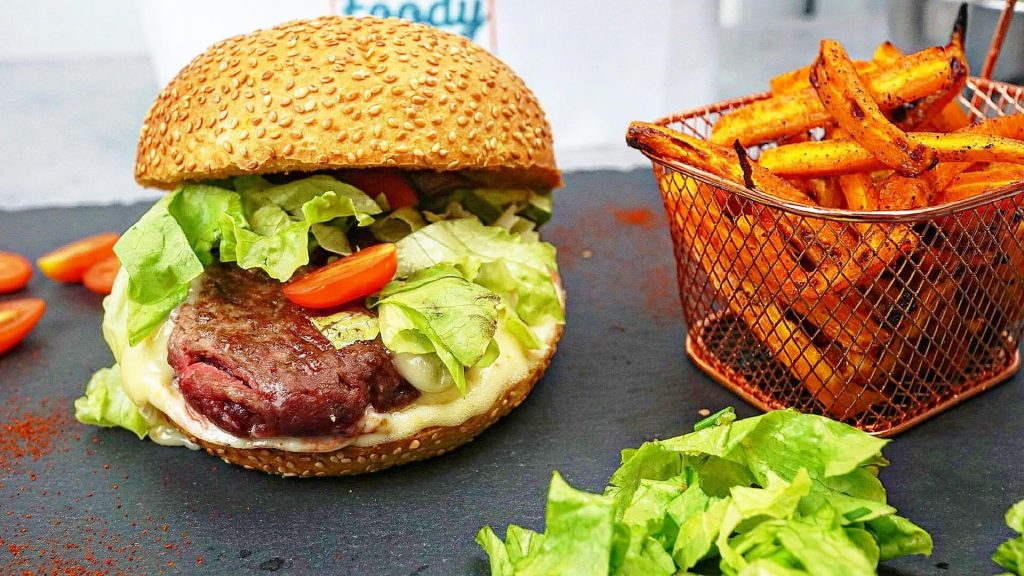 Burger au Munster coulant, oignons rouges caramélisés et frites de carottes