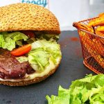 Burger au Munster coulant, oignons rouges caramélisés et frites de carottes