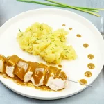 Brochette de poulet au satay et écrasé de pomme de terre aux herbes